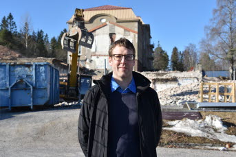 En man står framför byggarbetsplats.