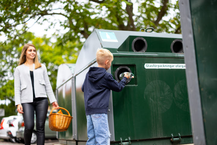 En kvinna och pojke källsorterar