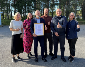 Sex personer står utomhus. De är glada över att ha fått utmärkelsen Norrlands Bästa Företagsklimat.