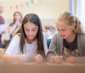 Två elever sitter vid ett bord i ett klassrum.