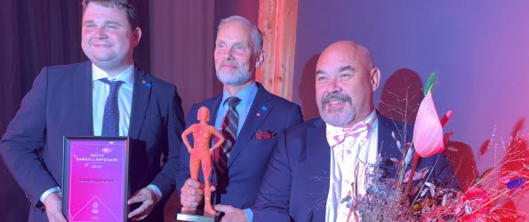 Tre män är glada över att ha tagit emot utmärkelsen Årets samhällsbyggare. Priset är en statyett som kallas Gloria.