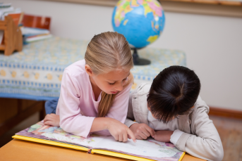 Skolelever läser en bok i ett klassrum