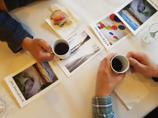 Händer som håller i kaffekoppar på ett bord.