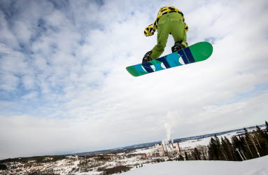 En snowboardåkare i luften som åker i Skönviksbacken.
