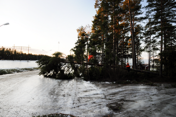 Två kvinnor står på en skolgård och tittar in i kameran och ler. Det är vinter ute.