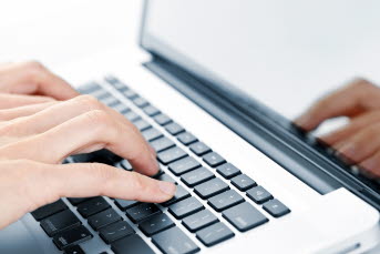 Bilden visar händer som skriver på ett tangentbord