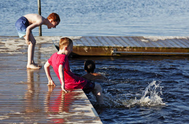 Bilden föreställer tre barn som badar.