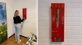 En elev trycker på en knapp på mensskyddsautomaten RedLocker. 