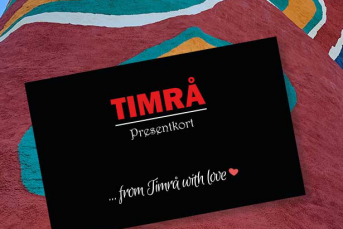 Närbild på ett svart presentkort. På presentkortet står det "Timrå presentkort. From Timrå with love".