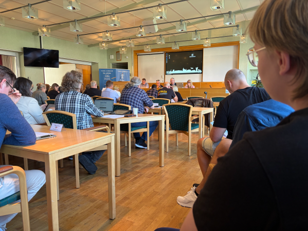 Bild på personer som sitter i salen där kommunfullmäktige hålls