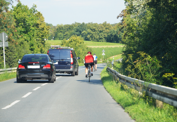 Bil kör om en cyklist