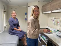 De två kvinnor som arbetar med projektet Proaktiv digifysisk seniorvård, är inne i bussen där patienterna undersöks.