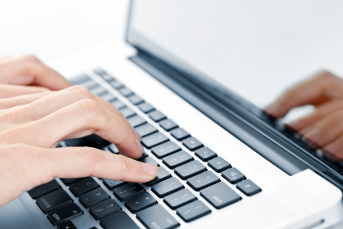 Händer skriver på en bärbar dator.