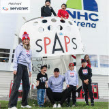 Bilden föreställer barn och vuxna som står utanför NHC Arena