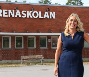 Annelie Granö-Sörell ler mot kameran med Arenaskolan i bakgrunden.