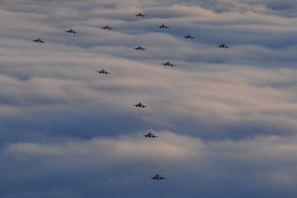 Bilden föreställer flera flygplan ovanför molnen