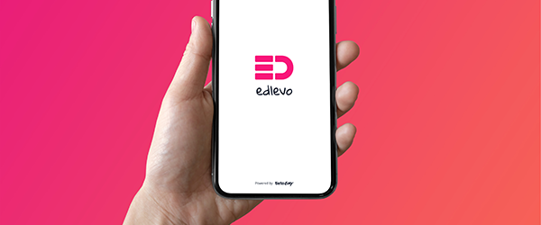 En person håller i en mobiltelefon som visar en logotyp som heter edlevo.