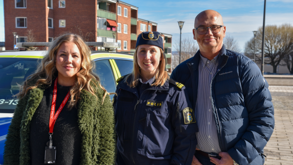 Tre personer står på rad och tittar in i kameran.