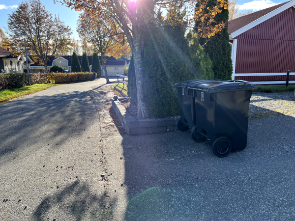 Två fyrfackskärl står cirka två meter från gatan