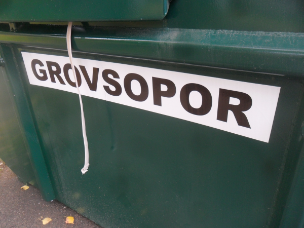 En grön container där det står "Grovsopor" med svart text på vit bakgrund.