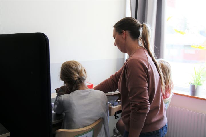 En lärare hjälper två elever.