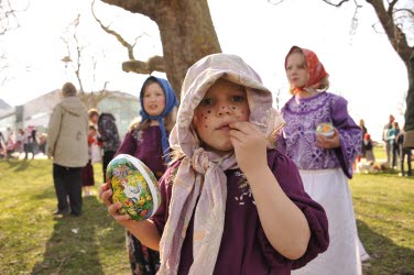 Barn utklädda till påskkärringar utomhus.