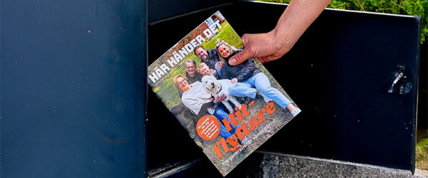 En hand tar ut en tidning från en brevlåda. På tidningen står det Här händer det i vit text och Hit-flyttare i orange text.