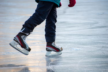 Barn åker skridskor på en is
