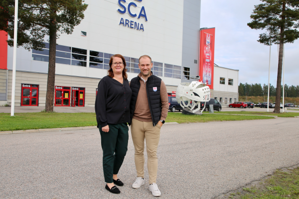 Två personer står framför SCA Arena i Timrå.