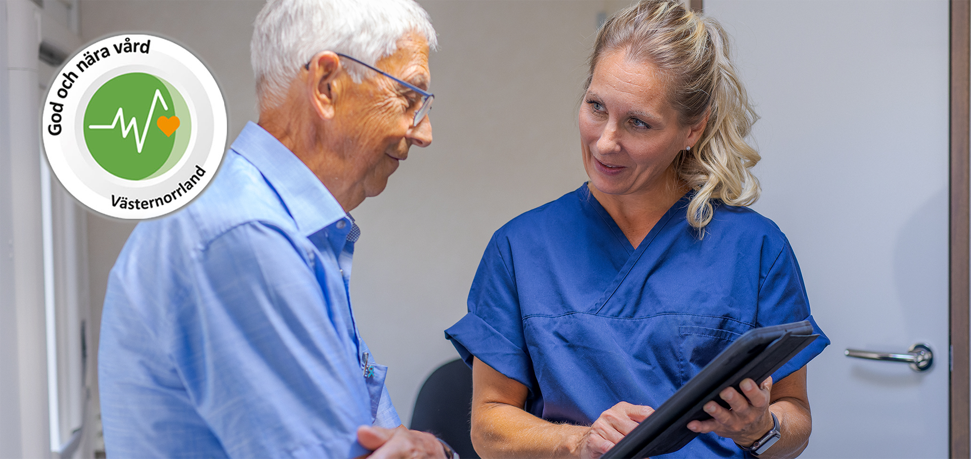 God och nära vård-symbolen ligger på ett foto föreställandes en äldre man som pratar med en kvinnlig sjuksköterska