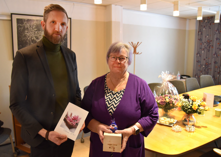 Peter Ekström håller i ett tackkort till Kristina som står bredvid där hon håller i sin gåva i kristall.