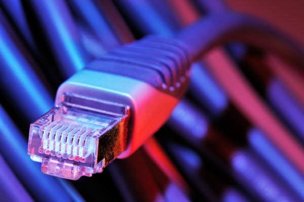 En nätverkskabel för internetanslutning i rött och blått sken.