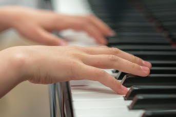 Två händer som spelar piano.