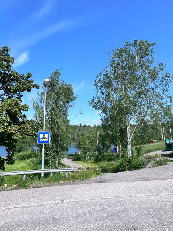En skylt för badplats som sitter på en lyktstolpe
