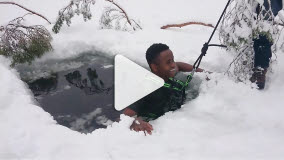 Eleven James badar isvak, han ser glad ut och har en sele runt livet.