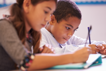 Skolelever läser en bok i ett klassrum
