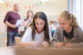 Två elever sitter vid ett bord i ett klassrum.