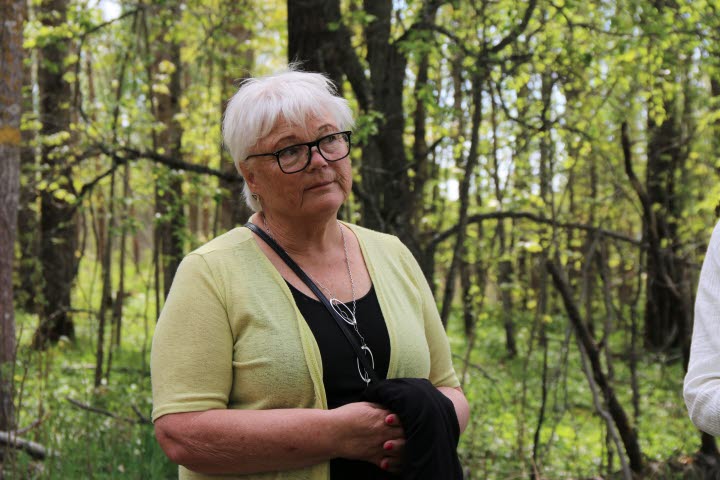 Lisbeth Eklund (S), ordförande i barn- och utbildningsnämnden, ler med en grön skog som bakgrund.